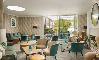 a modern lounge area with chairs , tables , and potted plants , providing a comfortable space for relaxation at Langstone Quays Resort