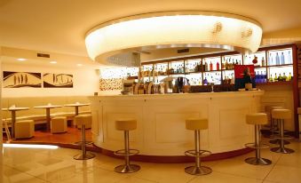 a modern bar with a curved counter and several stools , as well as a television mounted on the wall at Stern