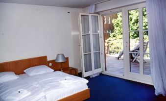 a bedroom with a bed and sliding glass doors leading to an outdoor patio area at Schlosshotel