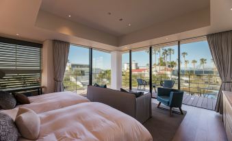 a luxurious hotel room with two beds , a couch , and a view of the ocean at Malibu Hotel