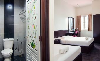 a hotel room with two beds , one on the left side and another on the right side of the room at Hotel Sri Bernam