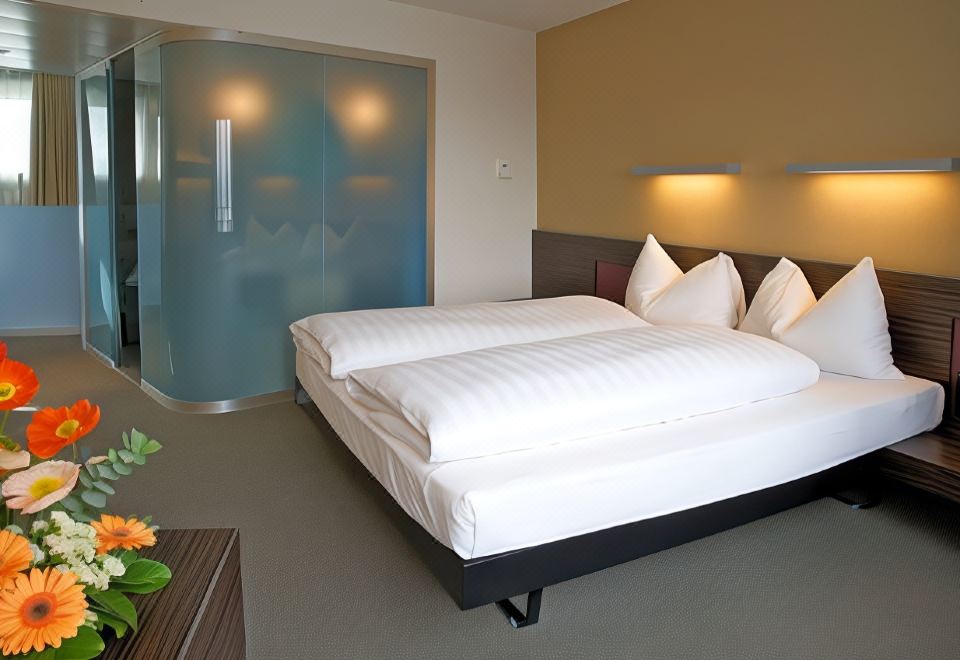 a hotel room with two beds , one on the left side of the room and the other on the right side at Hotel Ambassador