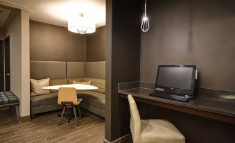 a cozy office space with a table , chairs , and a computer monitor , as well as a conference room in the background at Residence Inn Dayton Beavercreek