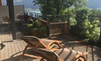 a wooden deck with two lounge chairs , one of which is folding , and a view of mountains in the background at The View
