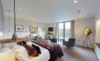 a modern hotel room with a large bed , comfortable seating , and a balcony view of the city at Low Wood Bay