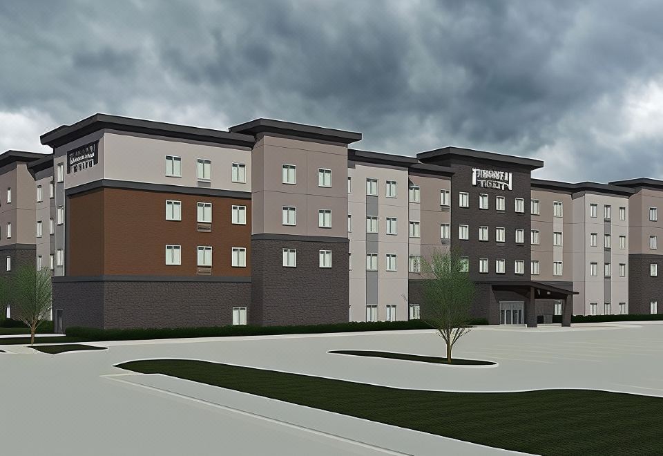 a large , modern hotel building with multiple floors and a cloudy sky in the background at Staybridge Suites Denver North - Thornton