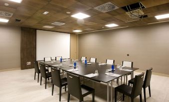 a conference room with a large table and chairs , blue cups , and water bottles on the table at Hotel Val de Neu G.L.