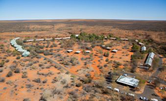 an aerial view of a desert landscape with a group of buildings and cars in the foreground at Discovery Resorts - Kings Canyon