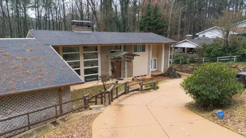 5-Bedroom 6000SF wood and glass retreat in Atlanta, surrounded by greenery.