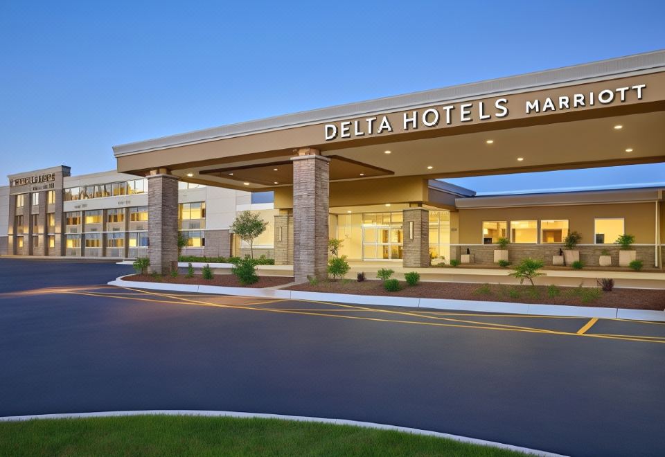 the exterior of a delta hotels maple leaf hotel , with its sign and amenities displayed on the building at Delta Hotels Chicago Willowbrook