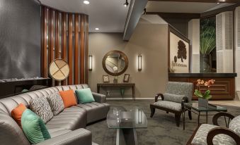 a modern living room with a couch , chair , and coffee table in front of a wooden wall at Best Western Plus Novato Oaks Inn