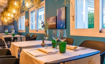 a dining room with two tables set for a meal , each adorned with wine glasses and cutlery at The Green Park Hotel