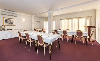 a conference room with tables and chairs arranged in a semicircle , ready for a meeting or event at Ingot Hotel Perth, Ascend Hotel Collection