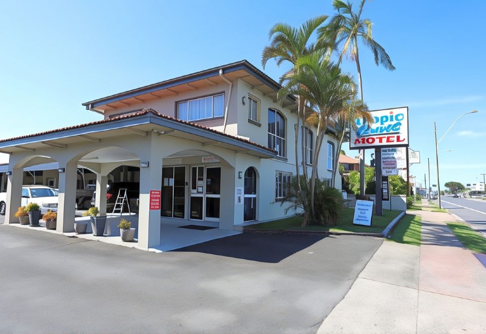 "a hotel with a sign that says "" tropic grand motel "" and a parking lot in front of it" at Tropic Coast Motel