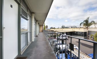 a balcony with a metal railing overlooks a parking lot and cars parked in the area at Nightcap at Westside Hotel