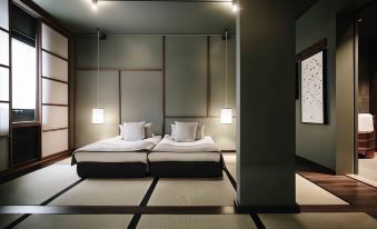 a room with two beds , one on the left side and another on the right side at Yasuragi