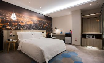 a hotel room with a white bed , a blue rug , and a large cityscape mural on the wall at Airline Inn Kaohsiung Station