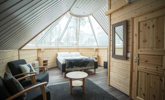 a cozy bedroom with a bed , chairs , and a round table is shown in this image at Northern Lights Village