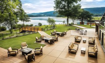 a patio area with a table and chairs overlooking a lake , creating a serene atmosphere at Rocky Gap Casino & Resort