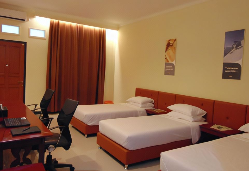 a hotel room with three beds , two of which are twin beds and one is a queen - sized bed at Wisma BPI