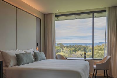 a bedroom with a large bed and a view of the outside through a window at Oval Hotel at Adelaide Oval, an EVT hotel