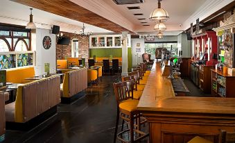 a restaurant with a long wooden bar and several chairs , creating a cozy atmosphere for patrons at Shannon Springs Hotel