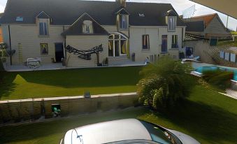 a driveway with a car parked in front of a house , surrounded by grass and trees at Villa Rosa