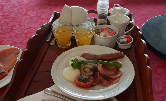 a wooden tray filled with a variety of breakfast items , including eggs , sausage , and toast at Tambaridge Bed & Breakfast