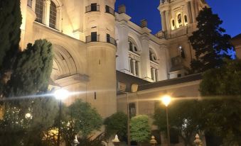 a beautiful night view of the building 's exterior , illuminated by lights and surrounded by greenery at Hilton Garden Inn Malaga