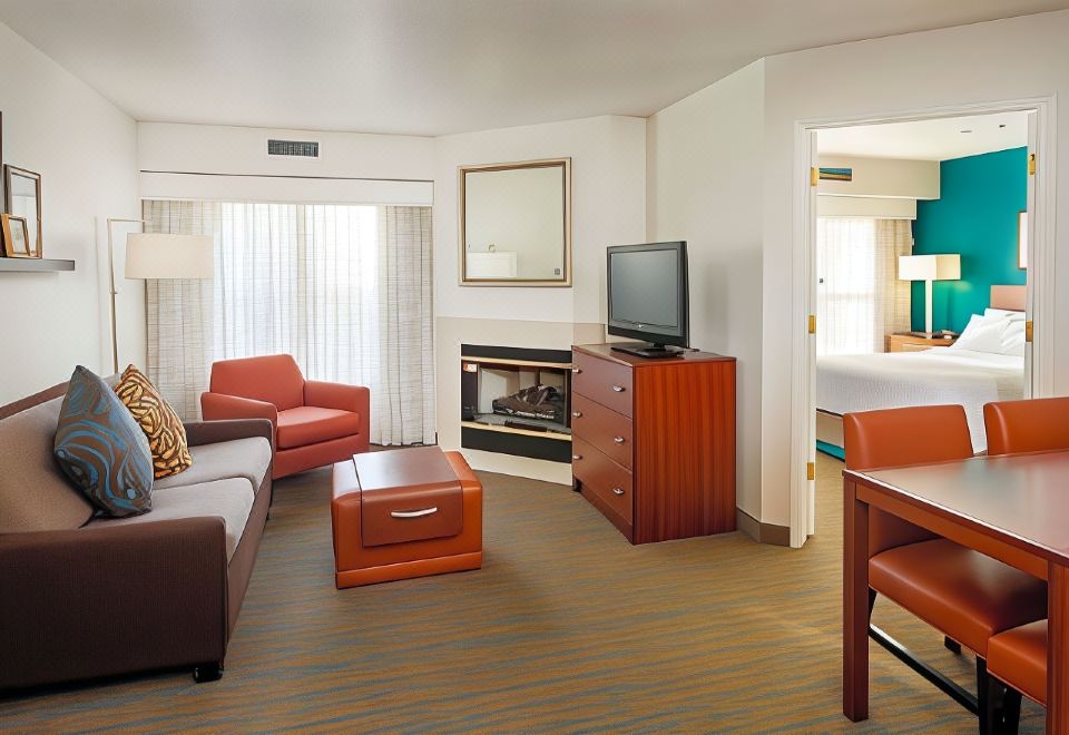 a living room with a couch , coffee table , and a tv . also a bed in the room at Residence Inn Stockton