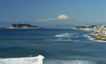 a snowy mountain in the background , with a body of water and a few boats visible in the distance at Sotetsu Fresa Inn Kamakura-Ofuna Higashiguchi