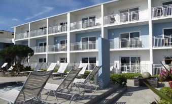 a row of chairs is set up in front of a blue building with white balconies at Lotus Boutique Inn and Suites