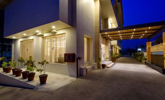 a modern building with a covered walkway and potted plants , creating a welcoming atmosphere at night at Regenta Central Jaipur