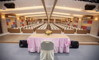 a large , empty conference room with multiple rows of tables and chairs set up for a meeting or event at MaiHom Villa