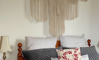 a cozy bedroom with a large bed , two nightstands , and a tassel hanging on the wall at Cambridge House Breakfast & Bed