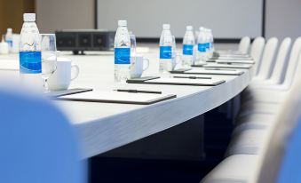 a conference room with a long table set up for a meeting , featuring several chairs and water bottles at Radisson Blu Aruba