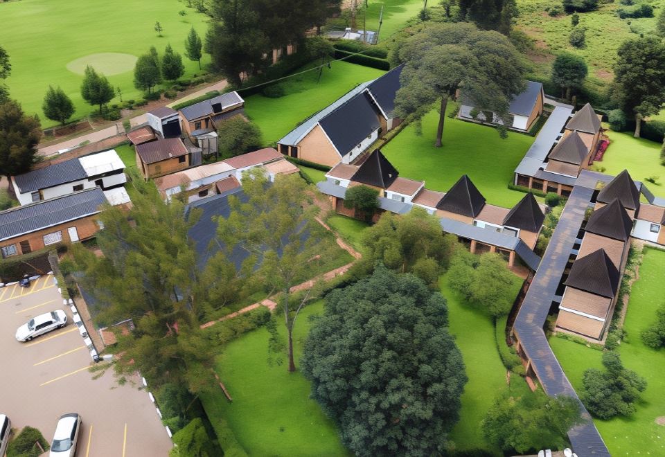 aerial view of a large green field with multiple houses and trees , including a golf course at White Horse Inn