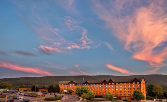 a large hotel building surrounded by a parking lot , with a beautiful sunset in the background at Rocky Gap Casino & Resort