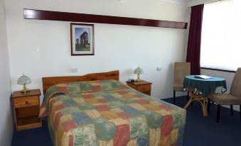 a hotel room with a bed , nightstands , and a picture on the wall , as well as a blue carpet at Mountain View Country Inn