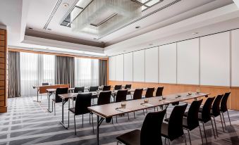 a conference room with rows of chairs arranged in a semicircle , and a projector on the wall at Stuttgart Marriott Hotel Sindelfingen