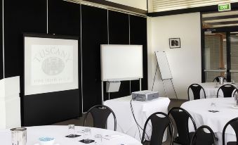 a conference room set up for a meeting , with tables and chairs arranged in rows at Estate Tuscany