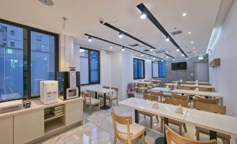 a modern , clean and well - lit restaurant with wooden tables and chairs , large windows , and modern equipment at Dubai Hotel