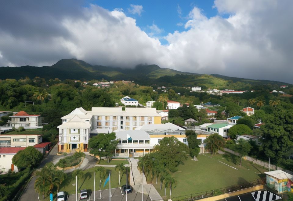 an aerial view of a large white building surrounded by greenery and mountains in the background at Hotel Saint - Georges