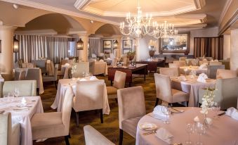 a large , elegant dining room with multiple tables and chairs arranged for a formal dinner at Beverly Hills