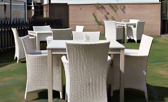 a patio with a dining table and chairs set up for outdoor dining , surrounded by greenery at The Woolpack Inn