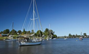 a large body of water with several sailboats docked on the shore , creating a picturesque scene at Waterview Motel Maclean