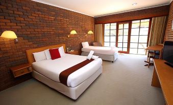 a hotel room with two beds , one on the left and one on the right side of the room at Grange Burn Motel