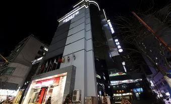 The building where a hotel is located is illuminated by neon lights at night at Hotel Zenith