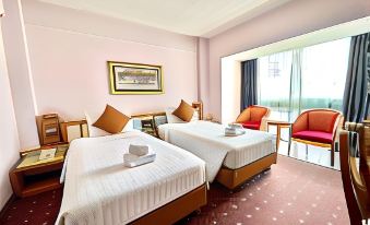 a hotel room with two beds , one on the left side and another on the right side of the room at Asian Hotel