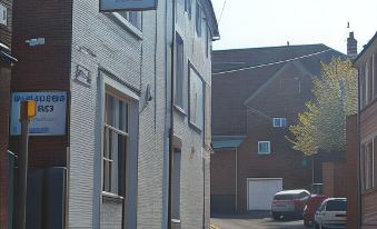 a narrow street with a brick building on one side and a car parked on the other at The Boot Inn